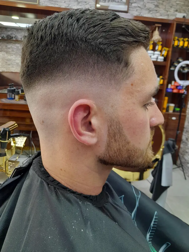 Side view of a fresh skin fade with a trimmed beard line