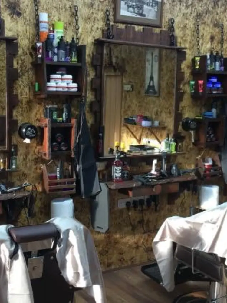 Mirrored barber stations with shelves of pomades and sprays